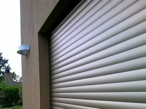 Persiana de aluminio de lamas marrones instalada en una fachada